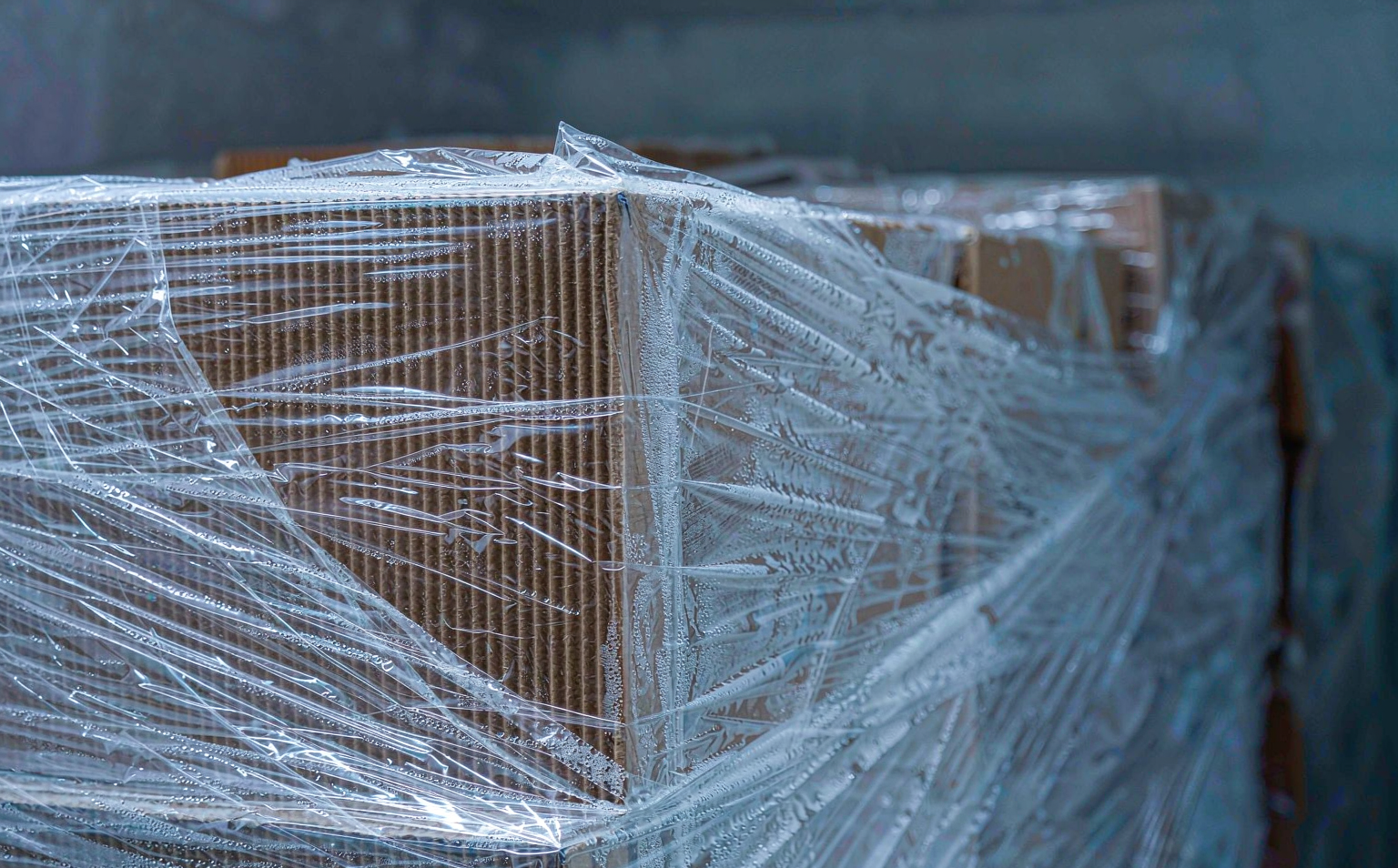 Close-up of frost and condensation on stretch film stretched over a carton corner in a freezer warehouse