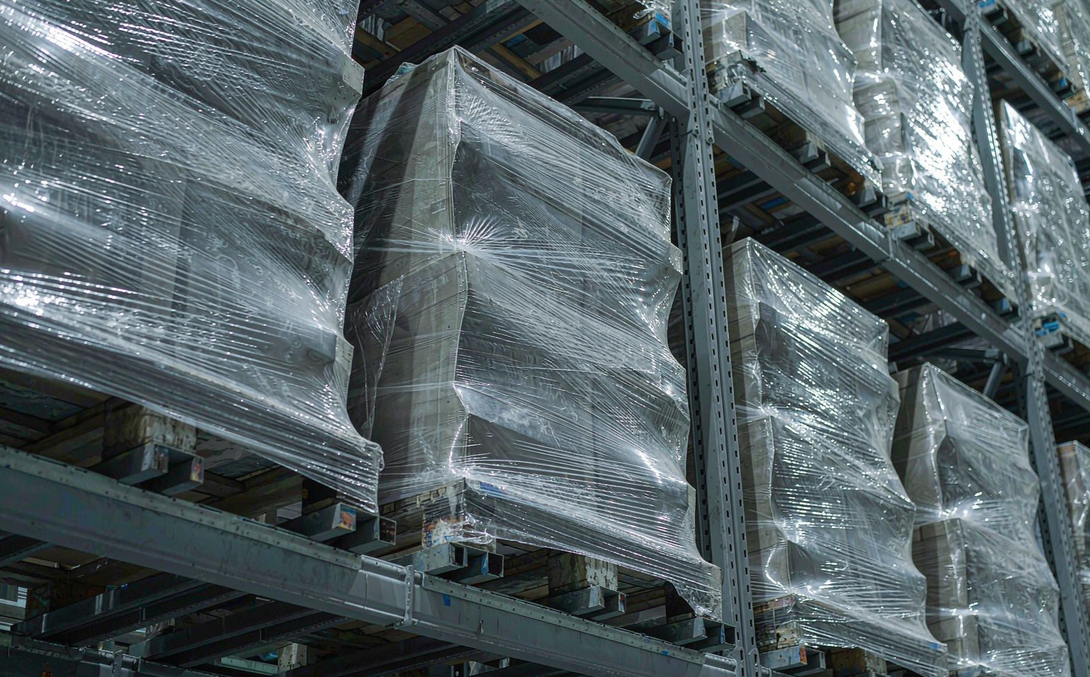 Tightly stretch-wrapped pallets with sharp-edged cartons stored in warehouse racking