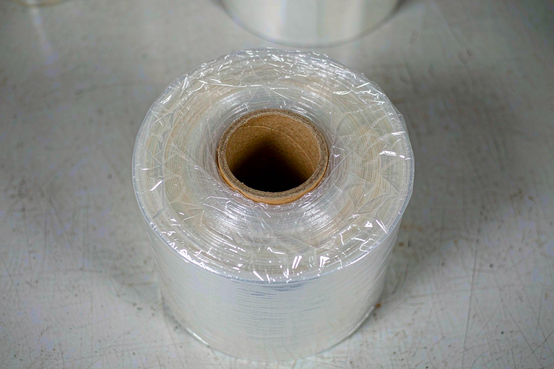 Close-up of a clear hand stretch film roll showing glossy film surface and cardboard core